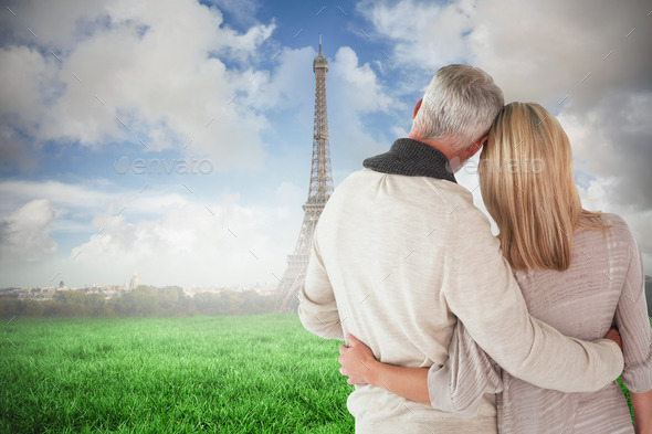 Happy couple standing with arms around against eiffel tower (Misc) Photo Download