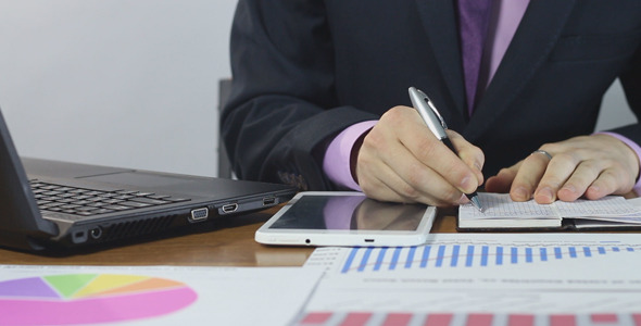 Businessman Typing on Laptop and Making Notes Businessman Typing on Laptop and Making Notes