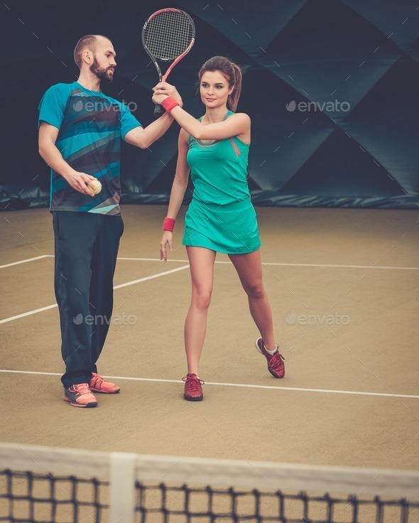 Woman player and her coach practicing on a tennis court (Misc) Photo Download