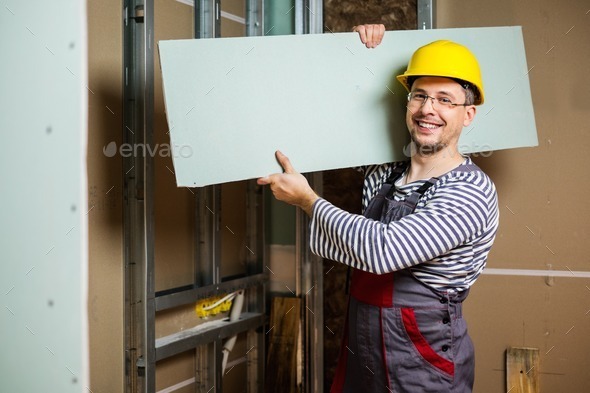 Builder with plasterboard in new building interior (Misc) Photo Download