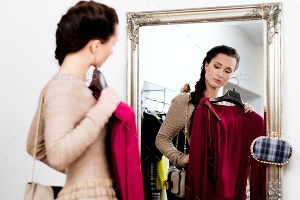 Young woman choosing clothes in a showroom (Misc) Photo Download