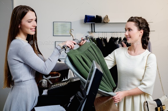 Happy woman customer paying in fashion showroom (Misc) Photo Download