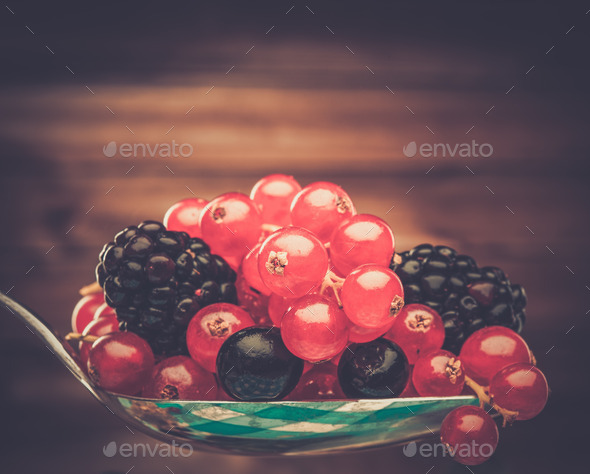 Fresh berries on a spoon against wooden background (Misc) Photo Download