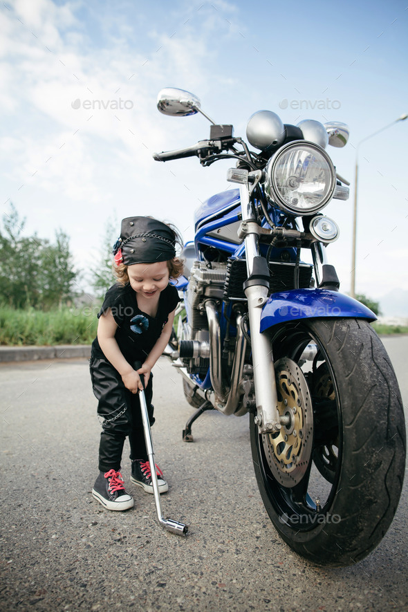 little biker repairs motorcycle on road (Misc) Photo Download