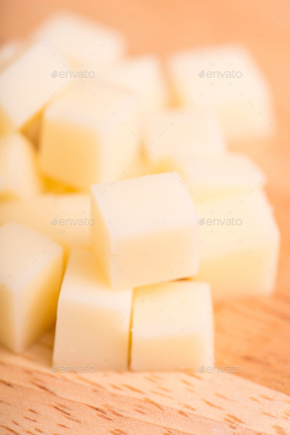 cheese cubes close up on wooden background - selective focus (Misc) Photo Download