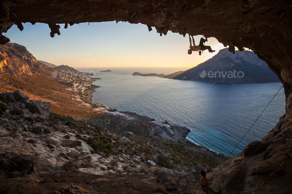 Male rock climber climbing along a roof in a cave at sunset (Misc) Photo Download