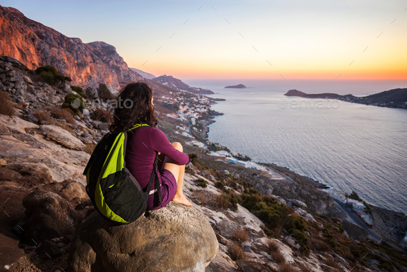 Rock climber having rest at sunset and enjoying beautiful view (Misc) Photo Download