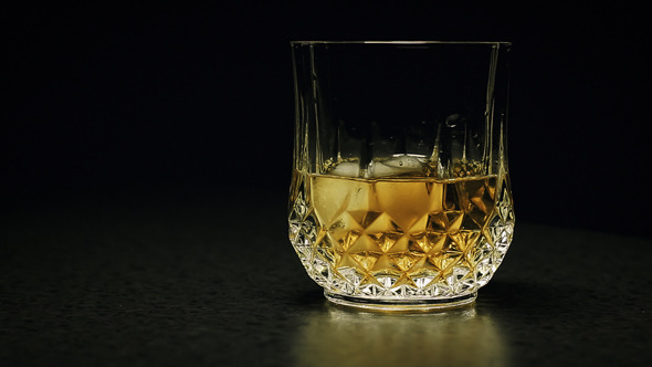 Serving Whisky into Glass with Ice Cubes Serving Whisky into Glass with Ice Cubes