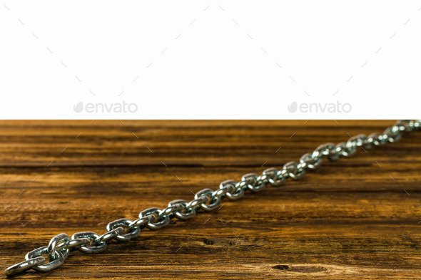 links of the steel chromeplated chain on wooden background