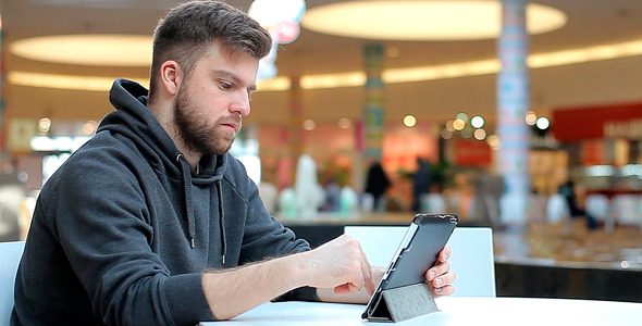 Man Working on a Tablet Screen is not Visible Man Working on a Tablet Screen is not Visible