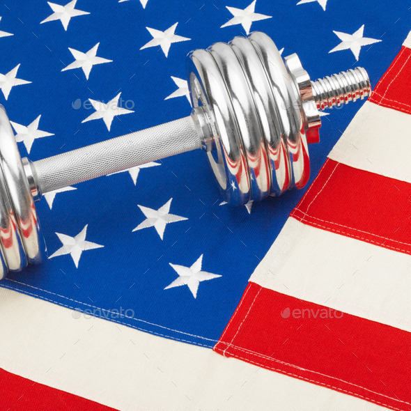 Metal dumbbell over US flag as symbol of healthy life style - studio shot (Misc) Photo Download