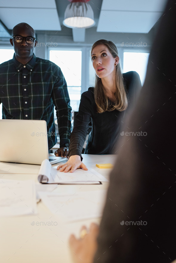 Woman showing new business proposal to coworkers