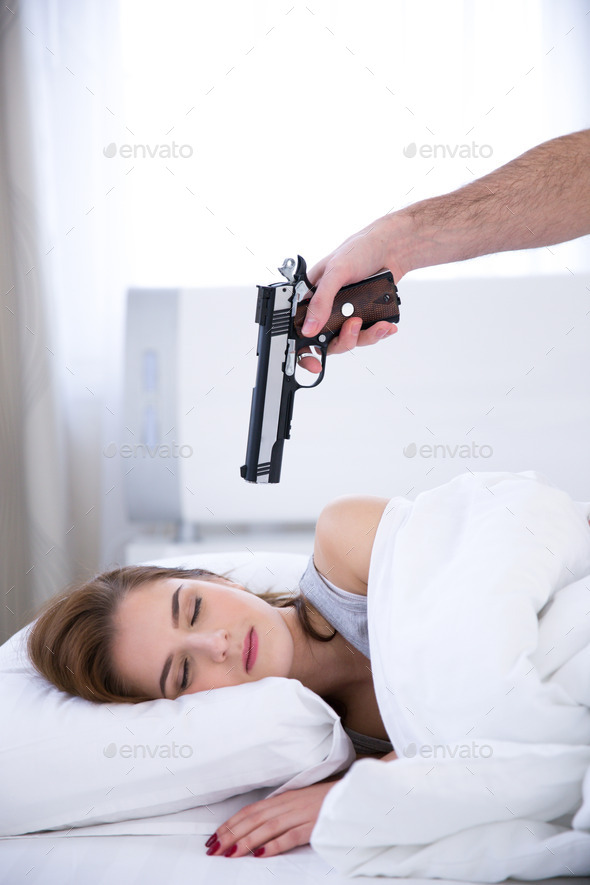 Young woman sleeping while the gun aimed at her