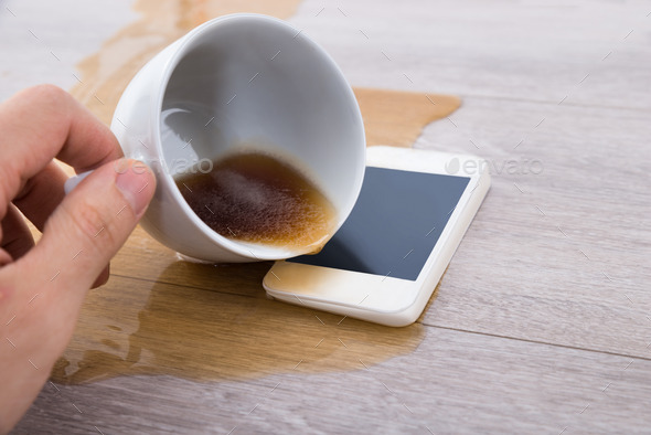 Person's Hand Spilling Coffee On Cellphone (Misc) Photo Download