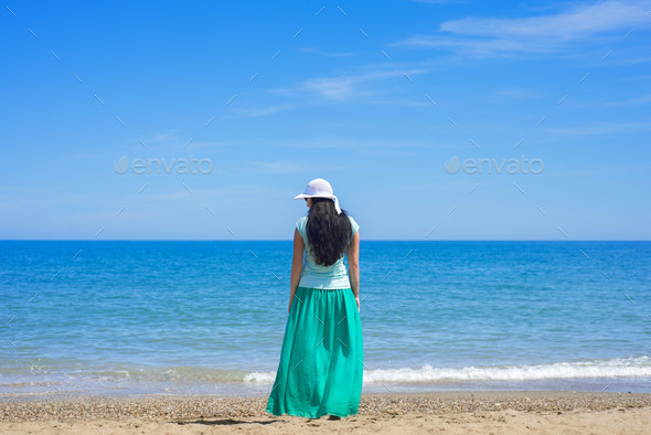Brunette female standing alone on the beach