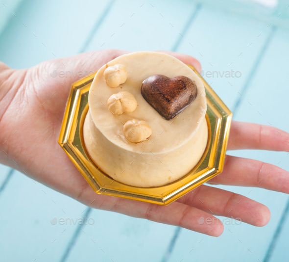 Small cake with hazelnuts in female hand. (Misc) Photo Download