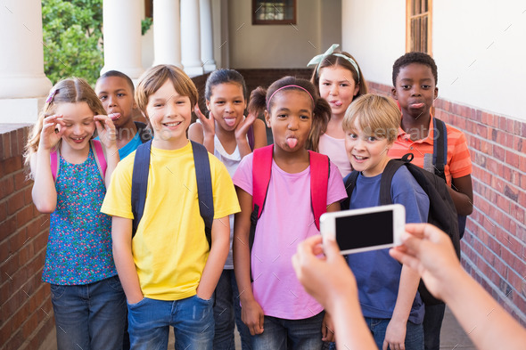 Cute pupils using mobile phone at the elementary school (Misc) Photo Download