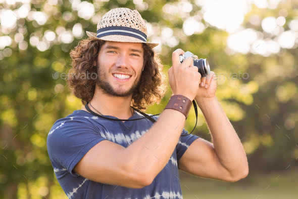 Handsome hipster using vintage camera on a sunny day (Misc) Photo Download