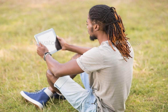 Handsome hipster using his tablet pc on a sunny day (Misc) Photo Download