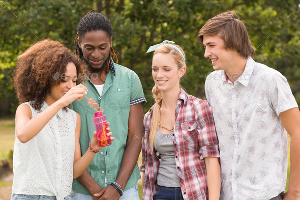 Happy friends in the park blowing bubbles on a sunny day (Misc) Photo Download