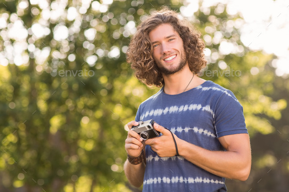 Handsome hipster using vintage camera on a sunny day (Misc) Photo Download