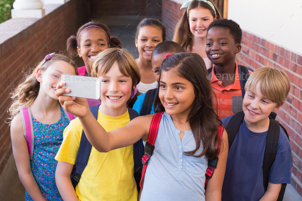 Cute pupils using mobile phone at the elementary school (Misc) Photo Download