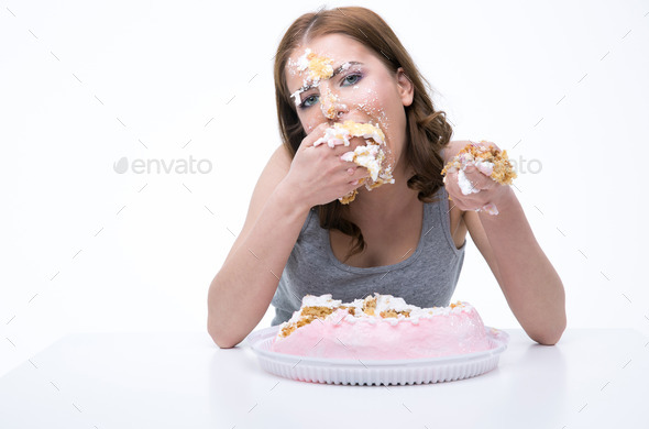 Beautiful woman sitting at the table and eating cake