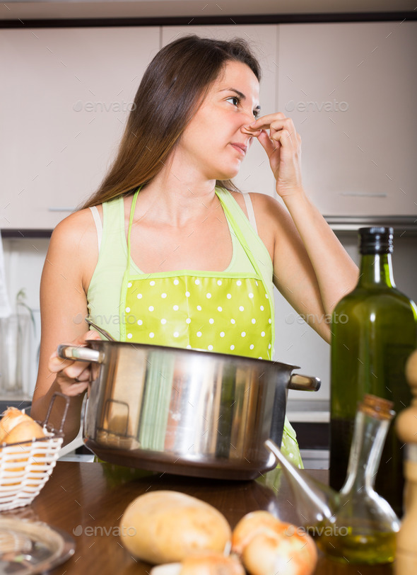 Housewife with bad smelling pan
