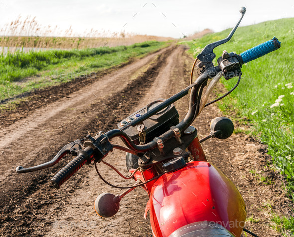 Classic old motorcycle on a dirt road. (Misc) Photo Download