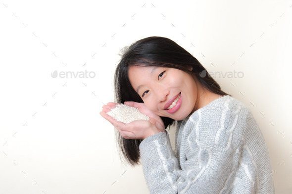 Smiling asian woman with rice in hands. Feed the world concept (Misc) Photo Download