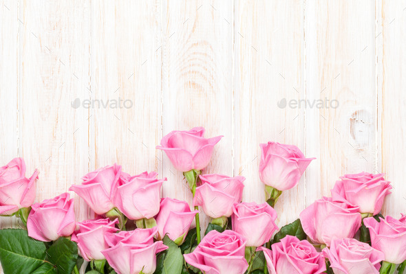Pink roses bouquet over wooden table