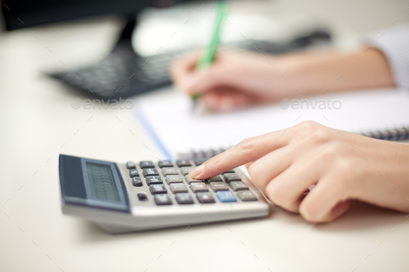 close up of woman with calculator taking notes (Misc) Photo Download