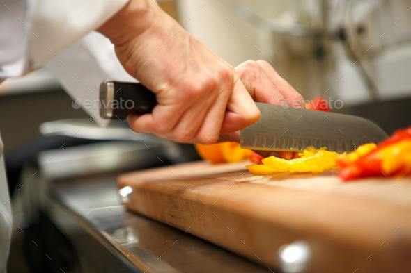 closeup on hands cutting yellow pepper