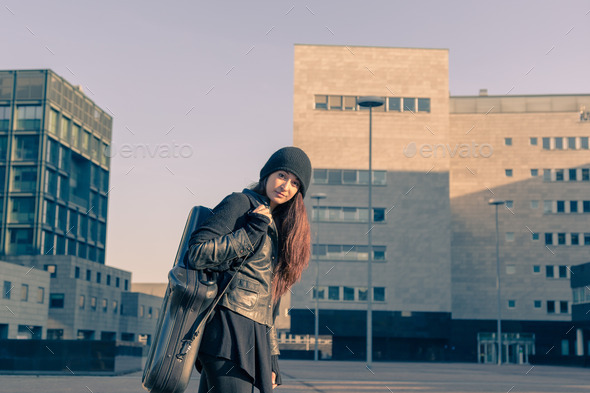 Beautiful young woman carrying saxophone case (Misc) Photo Download