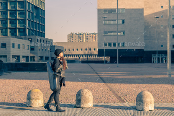 Beautiful young woman carrying saxophone case (Misc) Photo Download