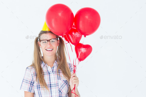 Geeky hipster smiling at camera and holding red balloons on white background (Misc) Photo Download