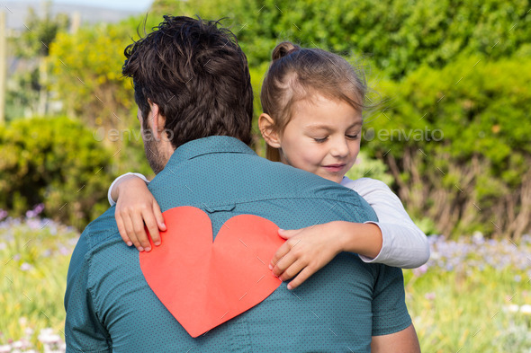 Daughter giving dad a heart card in the countryside (Misc) Photo Download