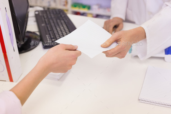 Pharmacist giving prescription to costumer at pharmacy (Misc) Photo Download