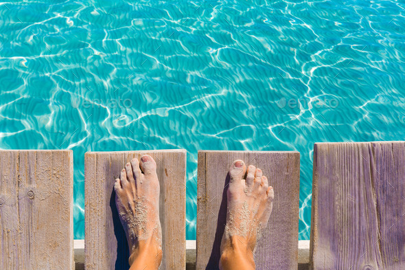 sandy feet on the pier tropical turquoise sea