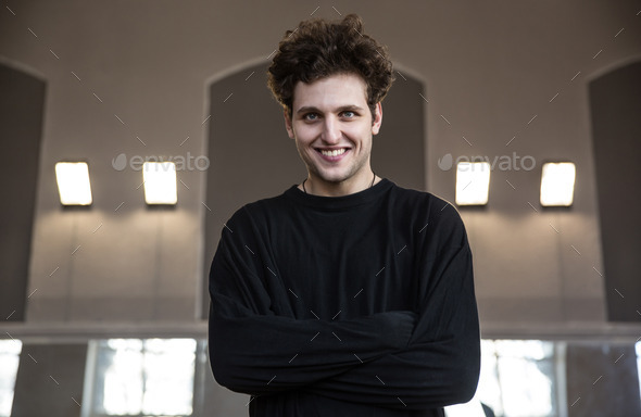 Portrait of a smiling young man with arms folded