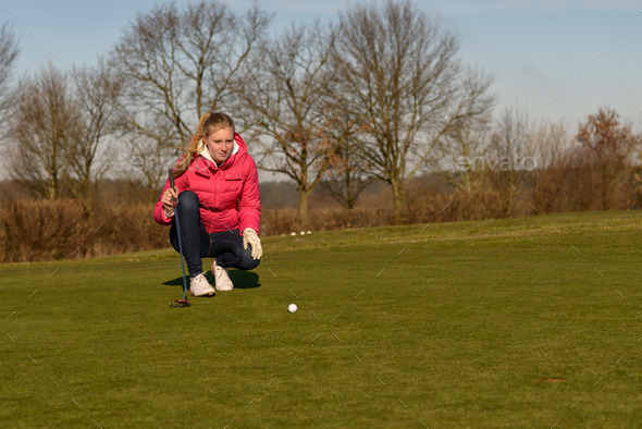 Female golfer lining up a putt