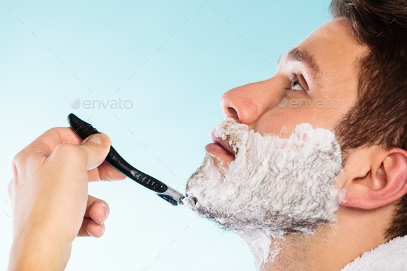 Man shaving with razor face profile