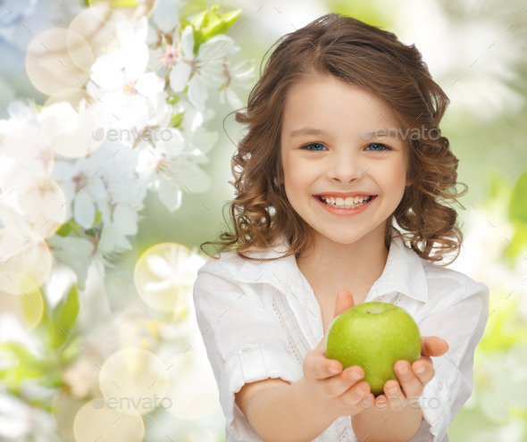 happy girl holding apple over garden background