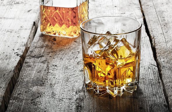 Faceted glass of whiskey with ice and a decanter (Misc) Photo Download