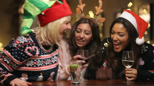 Group Of Female Friends Enjoying Christmas Drinks In Bar