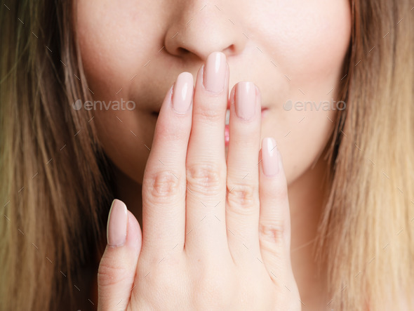 Part of face woman covering her mouth with hand