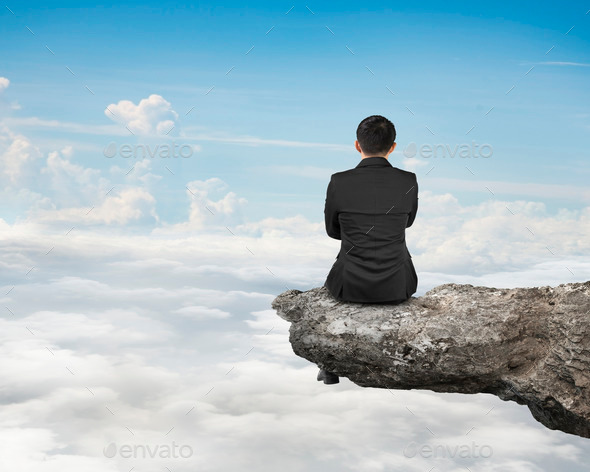 Rear view businessman sitting on cliff with natural sky cloudscape (Misc) Photo Download