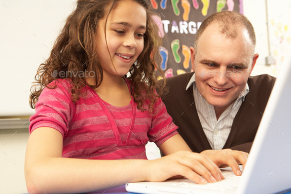 Schoolgirl In IT Class Using Computer With Teacher (Misc) Photo Download