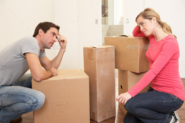 Young couple looking upset among boxes (Misc) Photo Download