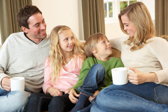 Happy young family sitting and talking on sofa (Misc) Photo Download